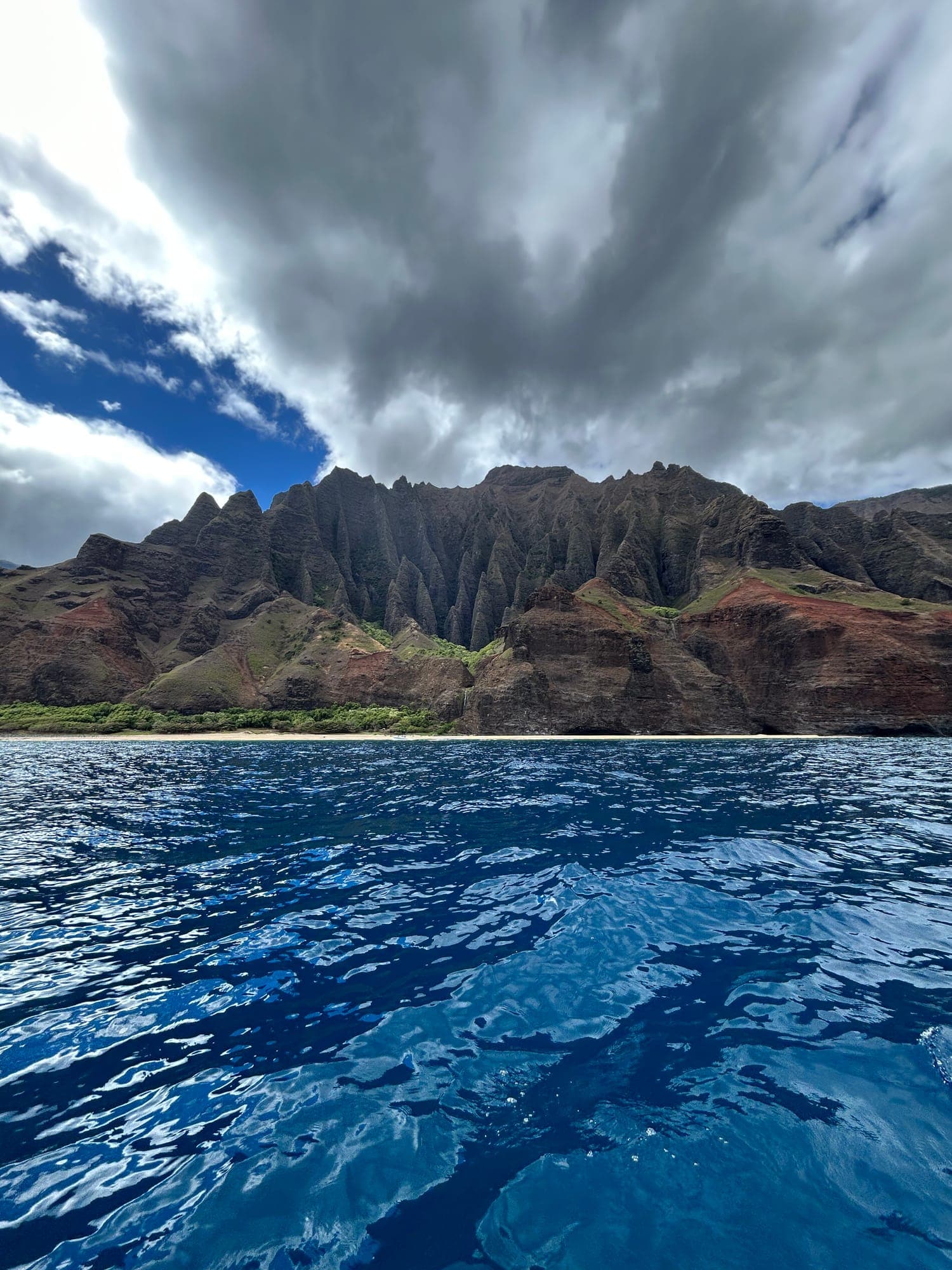 Green sea cliffs rising over deep blue water
