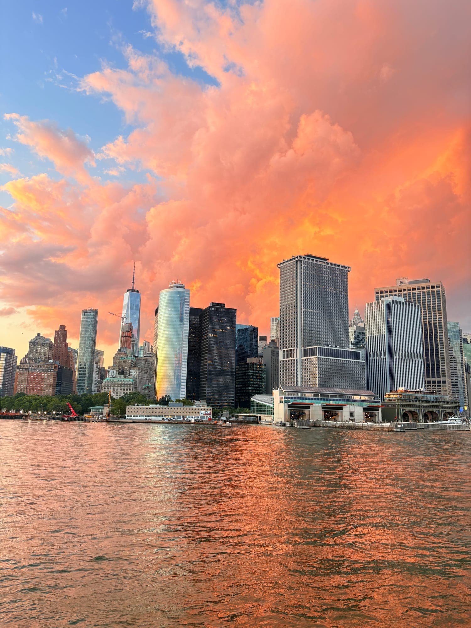 Lower Manhattan skyline under pink and orange clouds